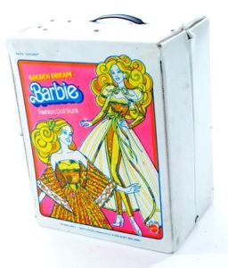 A vinyl case with a black handle on top. On the front is a large pink label that says, "Golden Dream Barbie, Fashion Doll Trunk." There are two blonde-haired Barbies on the cover, both wearing gold party outfits