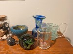 six pieces of blown glass of different colors - a bowl, a vase, a pitcher, a cup, a globe, an ornament.