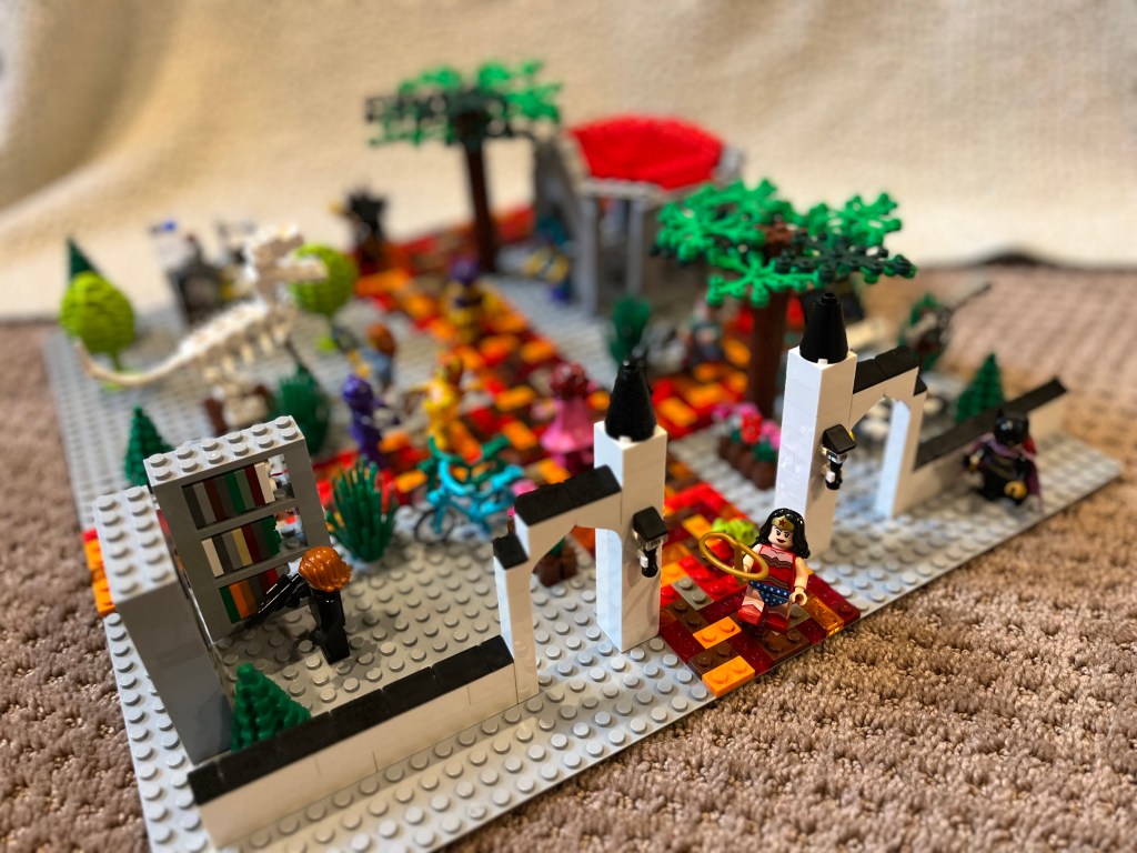 A Lego scene of the Indiana University campus from the Sample Gates. A Lego Wonder Woman figure stands at the entrance facing outward. The background is blurry.